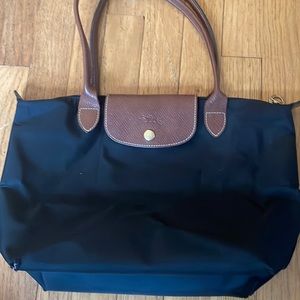 Longchamp Women’s small black purse. Minor scuff in lower corner of bag.
